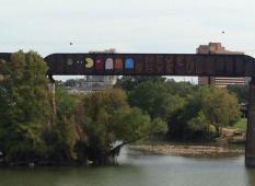 "Never Give Up" graffiti mural on the Austin Railroad Graffiti Bridge over Lady Bird Lake